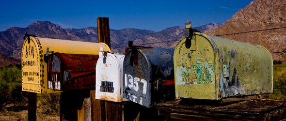 Row of mailboxes besides a mountain pass road.