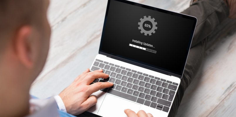 Laptop installing updates as part of following tax filing security tips.