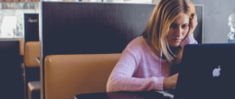 Tensed woman looking at laptop screen sitting in restaurant