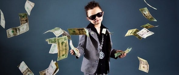 A little boy with sunglasses throwing money.