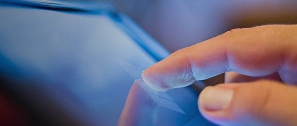 A finger pointing at the touch screen of a Digital tablet
