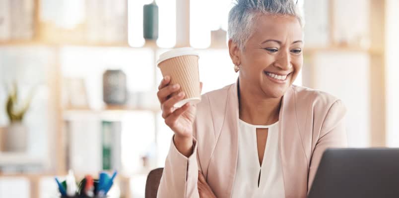 A smiling middle-aged woman deciding whether to enroll in a 401(k) or 403(b) retirement plan