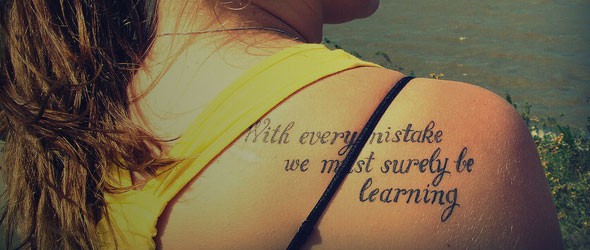 A tattoo on the back of a girl's shoulder which says 
