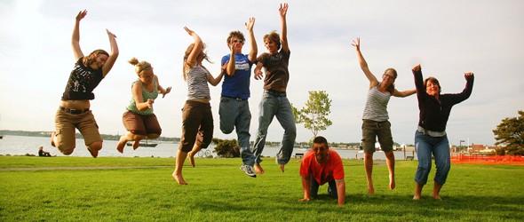 A group of parents jumping together in the green field