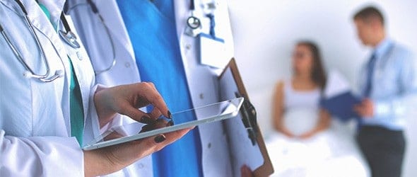 Healthcare professionals using a tablet during their discussion