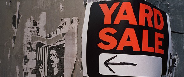 A poster showing direction of yard sale on a wall.