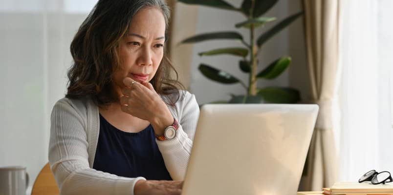 A woman looks thoughtful as she researches common tax filing mistakes and how to avoid them
