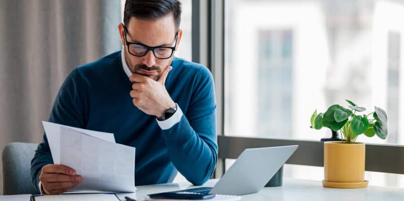 A man examines Form 1099-DIV as he files his taxes