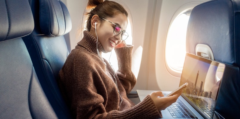 A young woman on an airplane traveling for business purposes