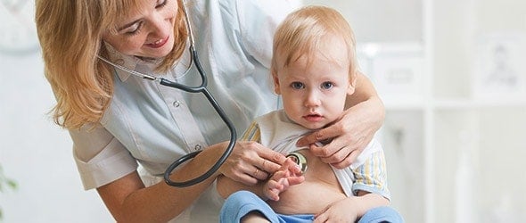 A doctor checking a baby boy with a stethoscope