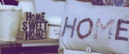 Text showing "HOME" on pillow cover,beside HOME SWEET HOME plaque and a bucket