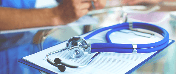 A blue stethoscope placed on a notepad