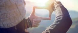 Close up of woman hands making frame gesture with sunrise