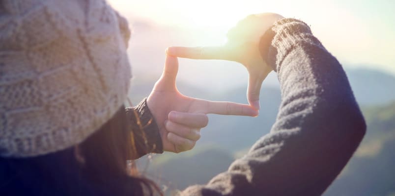 Close up of woman hands making frame gesture with sunrise