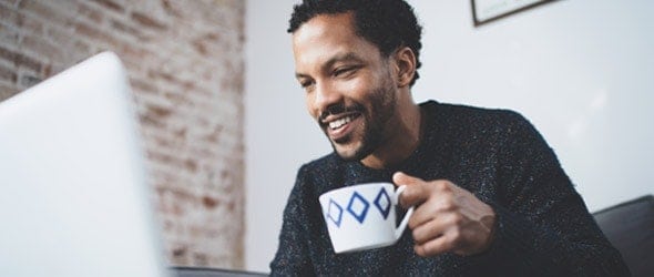 A man holding a cup of coffee with a smile on face