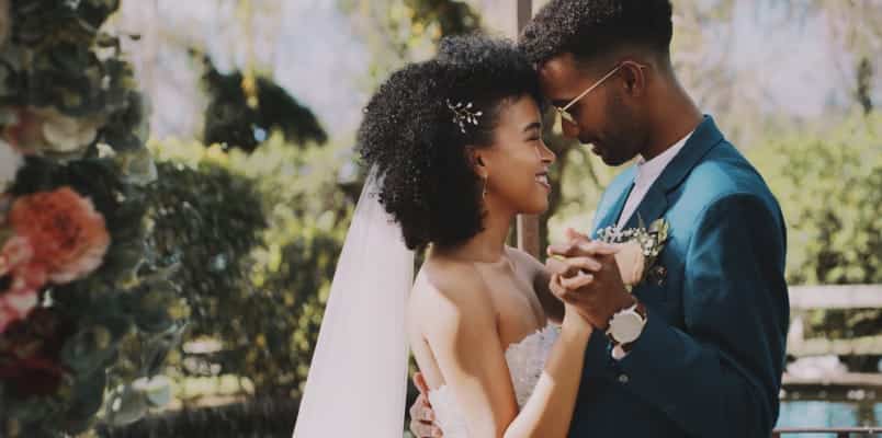 Bride and a Groom Holding Hands while Looking at Each Other