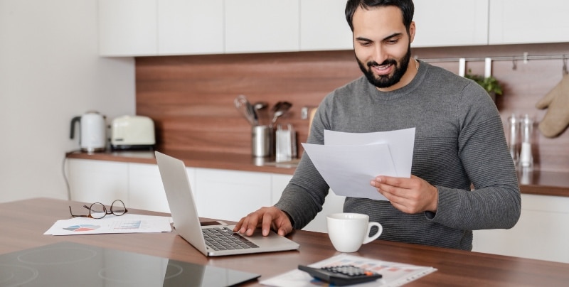 Man does tax paperwork in kitchen