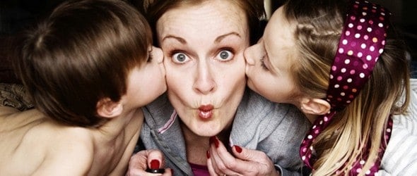 Mom making a pout while kissing by her children