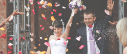 People showering flower petals on a newly wedded couple