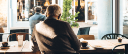 Back view of an elderly man sitting at coffee house.
