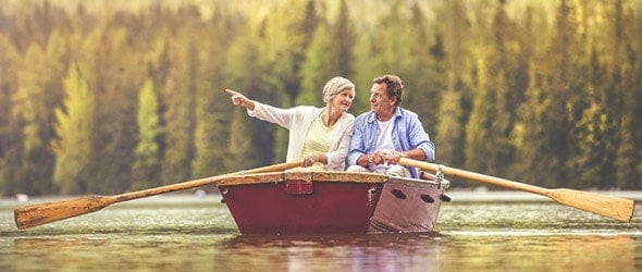 An old couple rowing a boat.