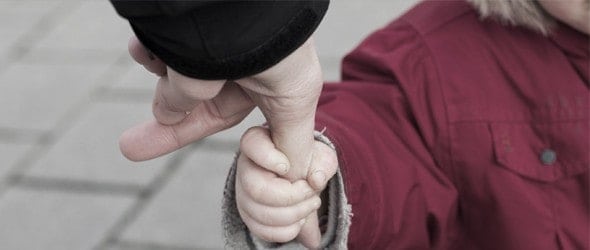 A child holding his parent's finger