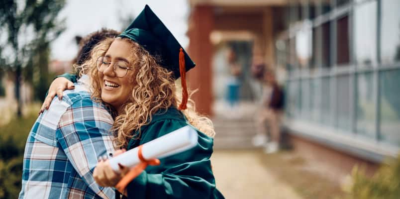 A graduating student hugs her parent