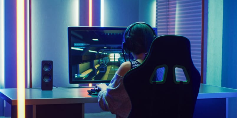 A lady playing video games at her desk