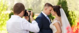 A photographer clicking photo of a bride and groom