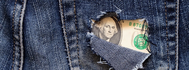 A torn jeans pocket having a dollar