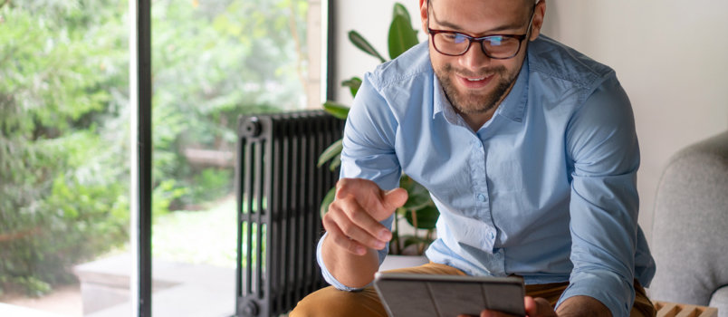 A man looking at his tablet and smiling